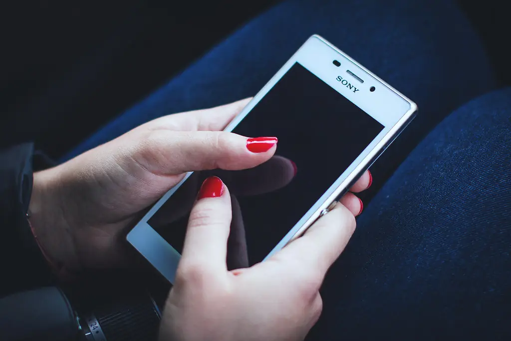 Mains tenant un smartphone